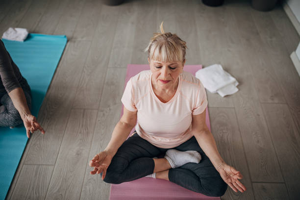 istock Senior woman meditating on yoga class 1300651979