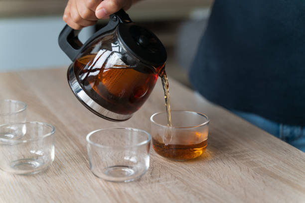 istock Glass teapot with blossoming tea and green tea cup 1300653707