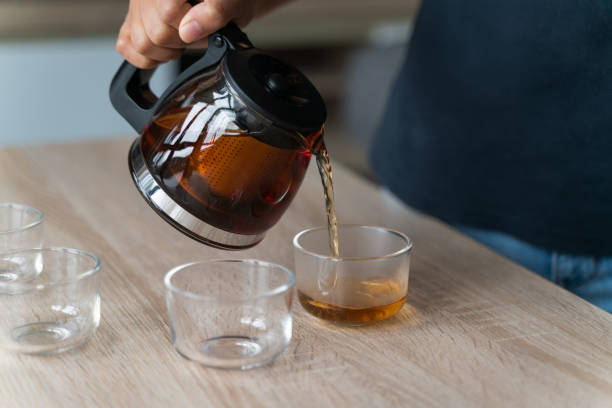 istock Glass teapot with blossoming tea and green tea cup 1300653708