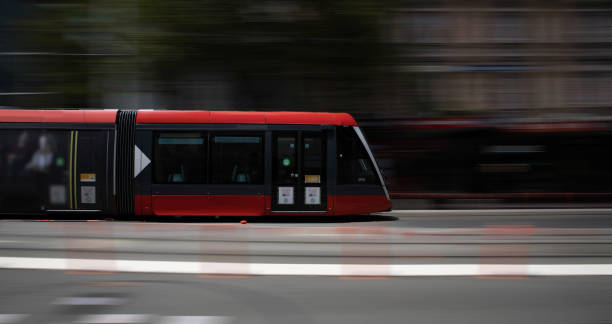 背景モーションブラーnswオーストラリアでチャイナタウンを通るシドニーの赤いトラム - overhead cable car 写真 ストックフォトと画像