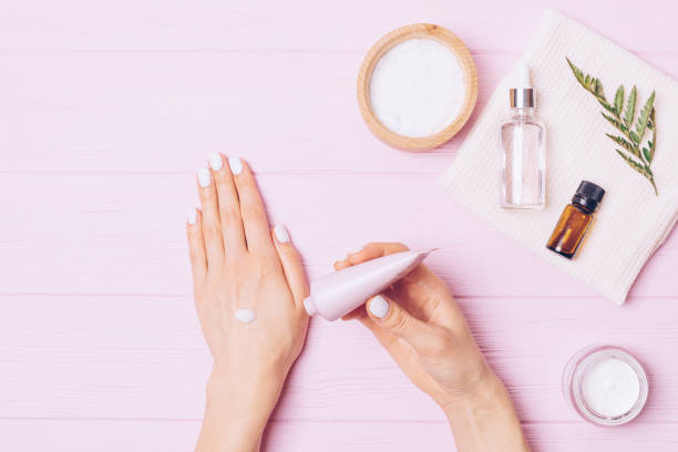 istock Top view of female hands applying moisturizing lotion 1300654026