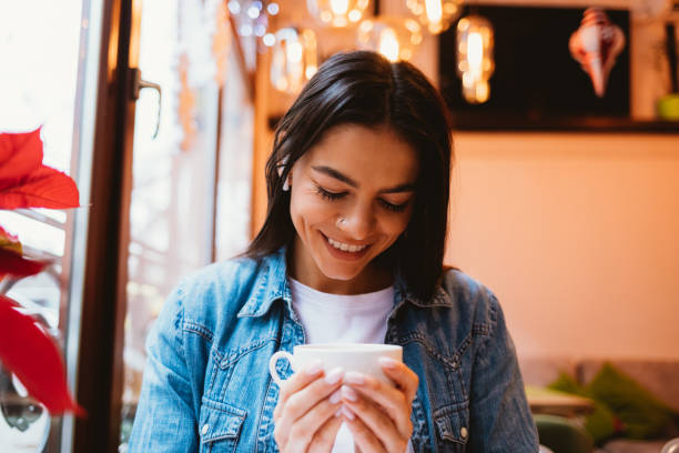 istock Attractive young woman sitting in cafe smiles 1300654096