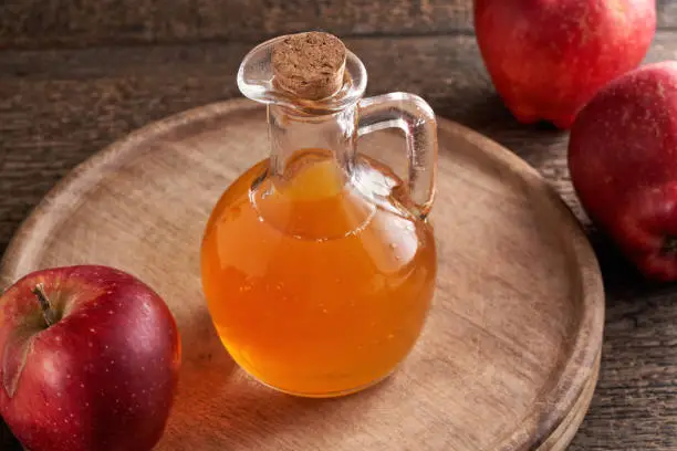 Apple cider vinegar in a bottle on a rustic table