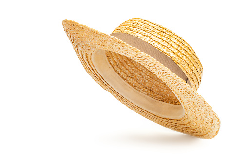 Boater straw hat flying isolated in studio. Concept of fashion clothing accessories and beach holidays