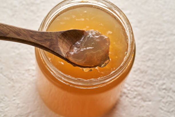 istock Cooled down congealed beef bone broth on a spoon and in a glass jar 1300655459