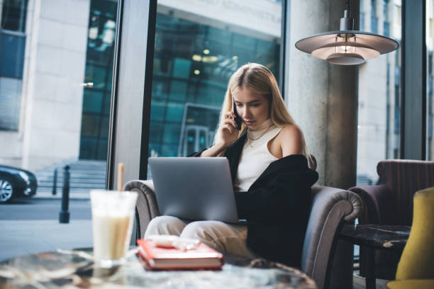 istock Serious woman with laptop talking on phone 1300656531
