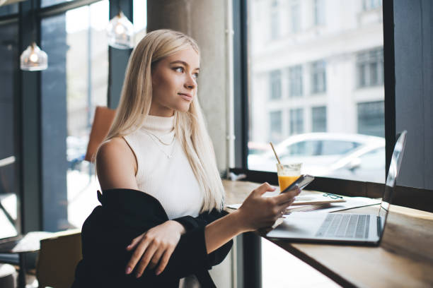 nachdenkliche frau mit smartphone in der hand arbeiten im café - prepossessing stock-fotos und bilder