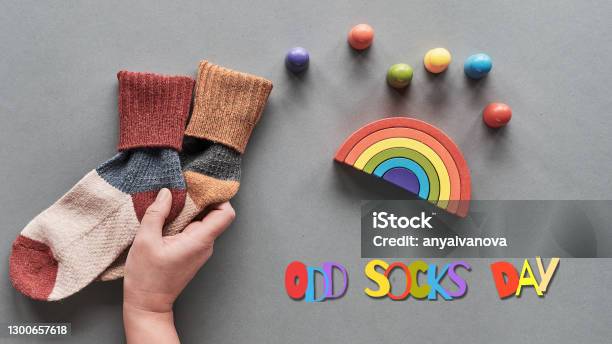 Odd Socks Day Hand Hold Pair Of Mismatched Socks Wooden Rainbow Toy Figures Social Initiative Against Bullying In School Or Workplace Design For Antibullying Campaign Promotion Poster Stock Photo - Download Image Now