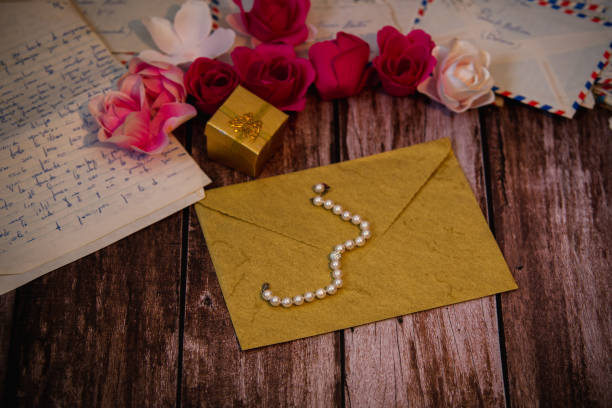 istock closed envelope with a pearl necklace on top and a gift box 1300657677