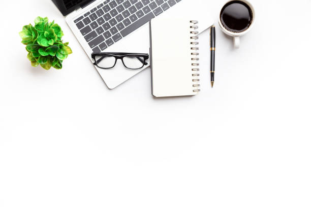 istock Flat lay, top view office table desk. Workspace with, laptop,office supplies, pencil, green leaf, and coffee cup on white background. 1300657923