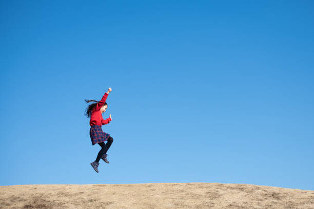 istock Girl jumping under the blue sky 1300657944