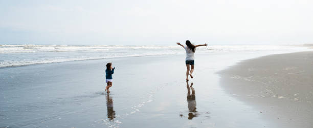 istock Parent and child running on beach 1300658085