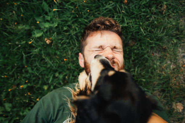 istock Young man is playing with a dog and do selfie 1300658212