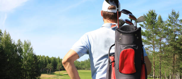 istock Golf player walking and carrying bag on course during summer game golfing. 1300659096