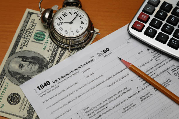 Funny character creature looking surprised and and trying to intimidate the viewer with words Tax Time. Depicted with female hand and googly eyes. Isolated on white with copy space