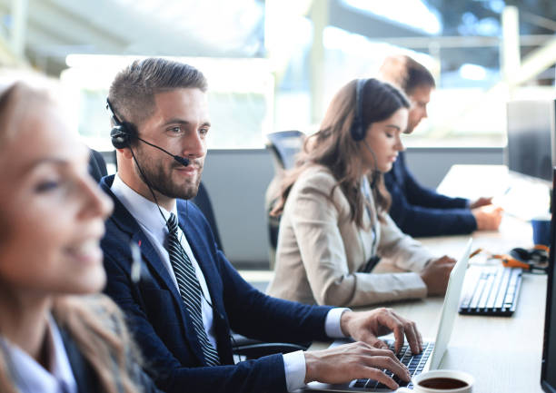 istock Portrait of call center worker accompanied by his team. Smiling customer support operator at work. 1300661054