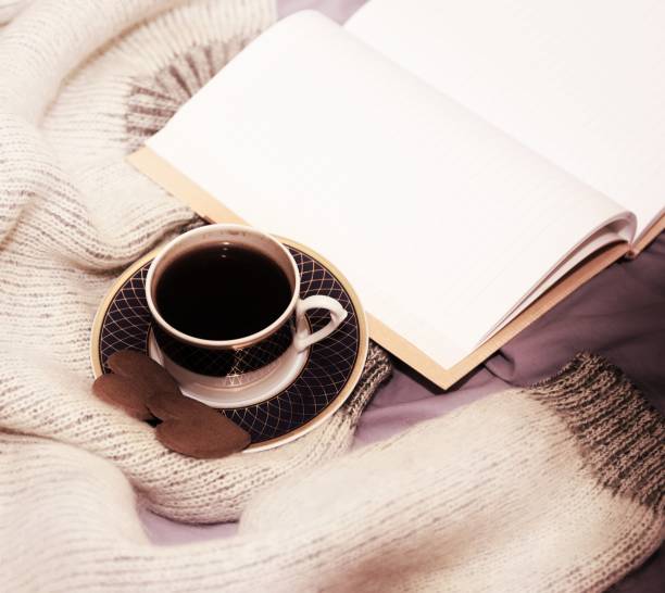 istock A cup of coffee, two gingerbread hearts and a blank open notebook on the bed 1300661574