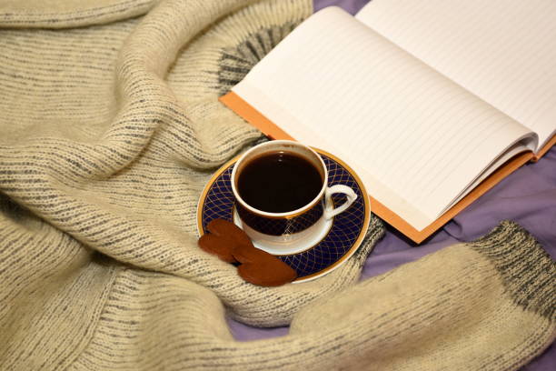 istock A cup of coffee, two gingerbread hearts and a blank open notebook on the bed 1300661577