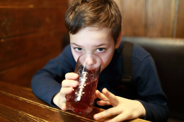istock Boy drinking juice in restaurant 1300664380