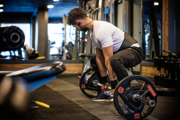 istock Young athlete lifting the barbell in gym 1300665005