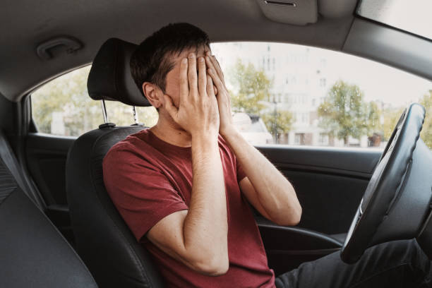 istock Young man covered his face with his hands in despair as he sat in his car. Overworked or a traffic accident and mistake concept 1300666255