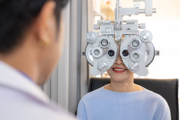 selective focus at optometry frame equipment. while doctor using penlight and subjective refraction to  examine eye visual system of elder patient women with professional machine before made glasses. - penlight imagens e fotografias de stock