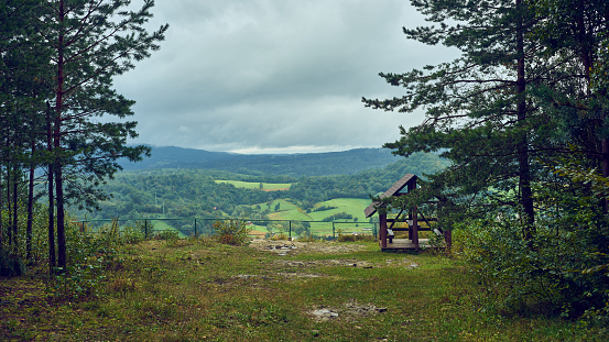 Viewpoint with a wooden shelter. Peaceful resting place on the trail among trees with the view from a quarry cliff in Bieszczady, Poland