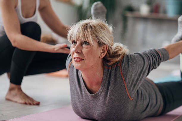 istock Yoga instructor assisting woman on yoga class 1300668178