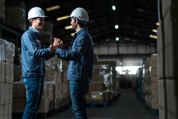 istock successful engineer teamwork casual positive converation working together in warehouse factory.Male worker with safety helmet checking quantity quality of product boxes on storage shelf in warehouse 1300668363