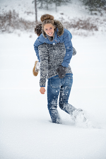 Couple playing in the snow. Man carrying woman on his shoulder. Candid interaction. Deep Fresh Powder Snow. Nikon Z7ii. Converted from RAW.