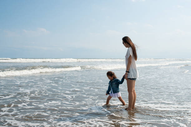 istock Mother and daughter playing at the beach 1300675561