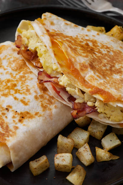 istock The Folded Breakfast Tortilla with Scrambled Eggs, Bacon, Tomato and Cheese 1300680877