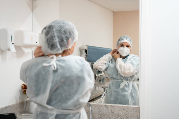 istock Doctor wearing protective clothing looking at herself in the mirror 1300680903