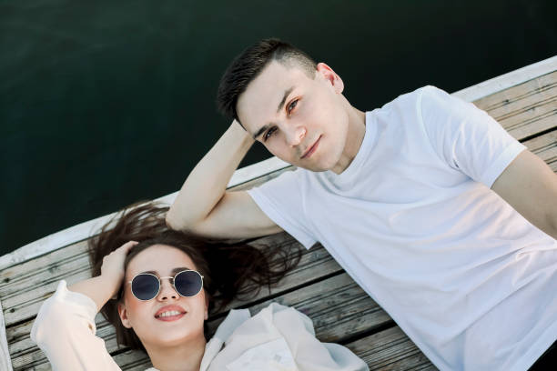 istock Young couple relaxing on pier in summer 1300681009