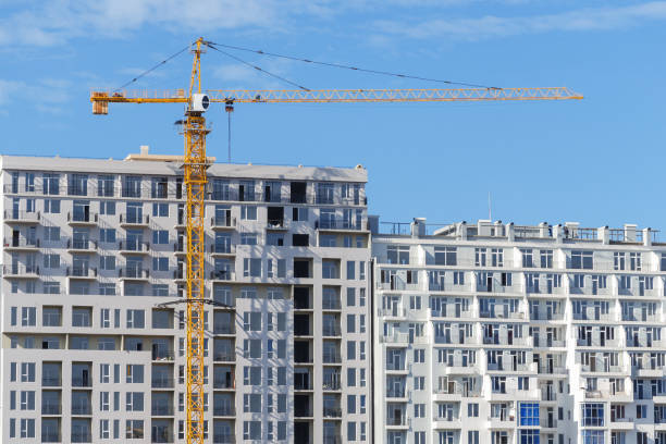 istock Tower construction crane in front of finished  apartment building. 1300682290
