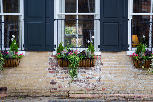 Window boxes and exposed brick on the side of a home in Charleston, South Carolina