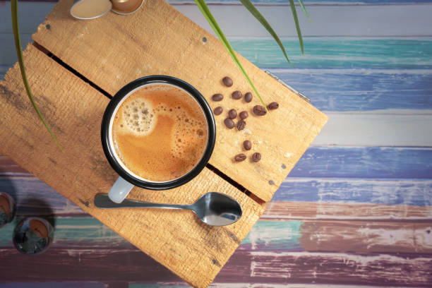 istock A white coffee cup with cream coffee stands on a colored wooden wooden surface. 1300683629