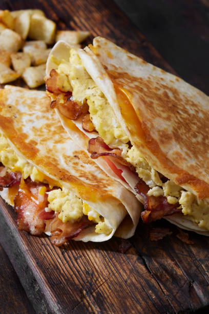 istock The Folded Breakfast Tortilla with Scrambled Eggs, Bacon, Tomato and Cheese 1300684671