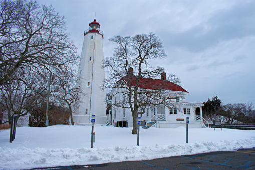 Lighthouse in Sandy Hook, New Jersey, at dusk, a day after a heavy snowstorm, with the light turned on