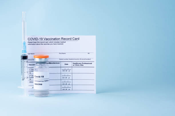 Covid-19 vaccine vial, vaccination record card, syringe, on a blue background. Covid-19 vaccine vial, vaccination record card, syringe, on a blue background, copy space, close up. Coronavirus vaccination concept. immunization certificate photos stock pictures, royalty-free photos & images