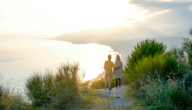 istock Drone view of couple watching sunset over sea 1300689547