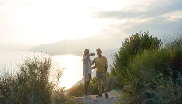 istock Drone view of couple watching sunset over sea 1300689628