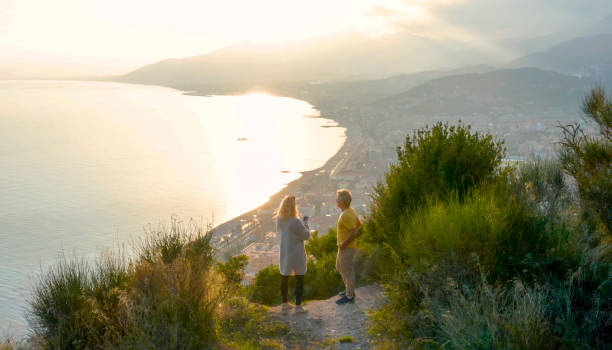 istock Drone view of couple watching sunset over sea 1300689632
