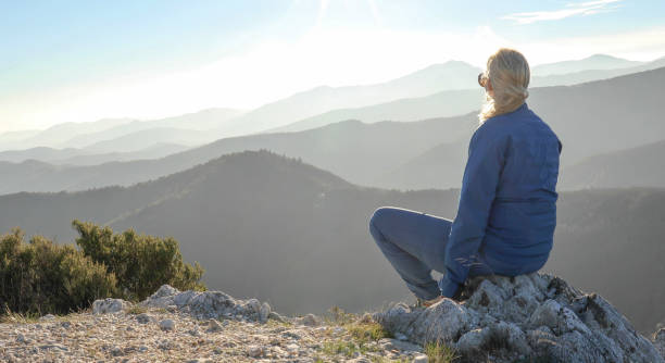 istock Woman watches sunset on mountain ridge 1300689649