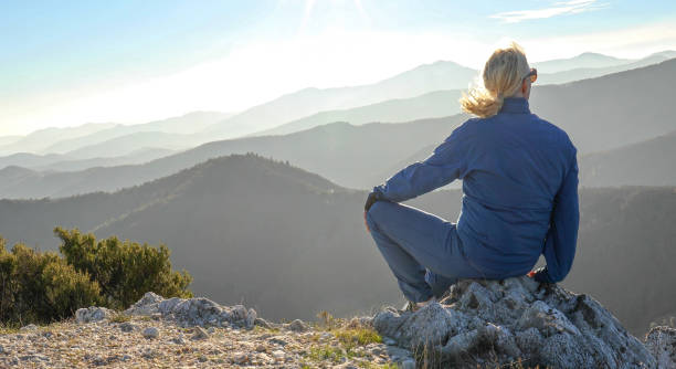 istock Woman watches sunset on mountain ridge 1300689676
