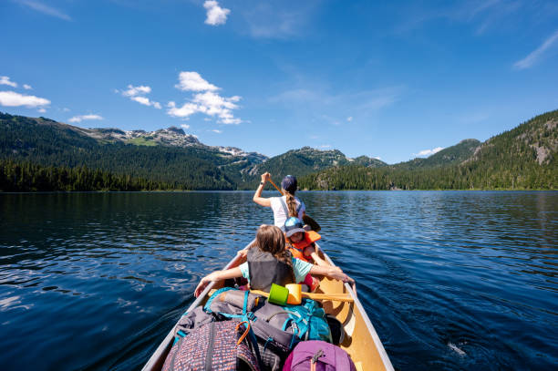 istock Family canoeing on a stunning mountain lake 1300689731