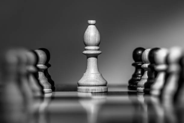Chess White bishop on chessboard Chess White bishop on chessboard, surrounded by White and Black pawns, Only bishop in focus. pawn chess piece photos stock pictures, royalty-free photos & images