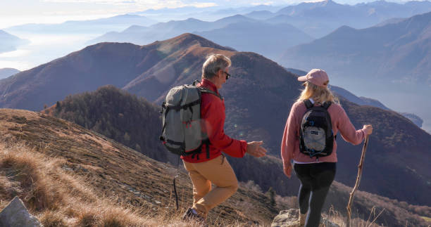 istock Mature couple hike along sunny mountain ridge 1300696090