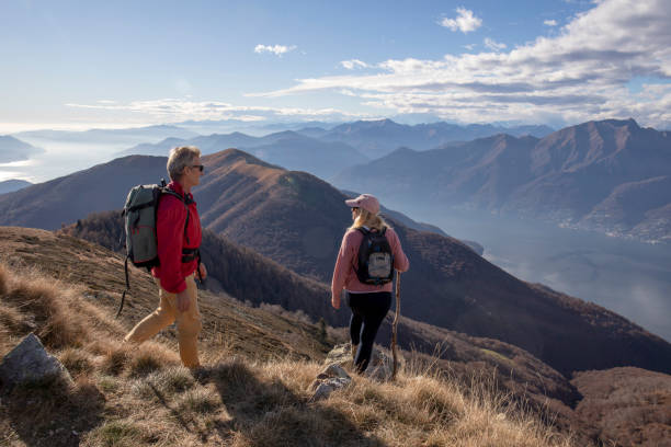 istock Mature couple hike along sunny mountain ridge 1300696344