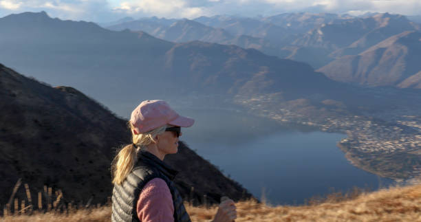 istock Female hiker walks above lake and mountains 1300696615